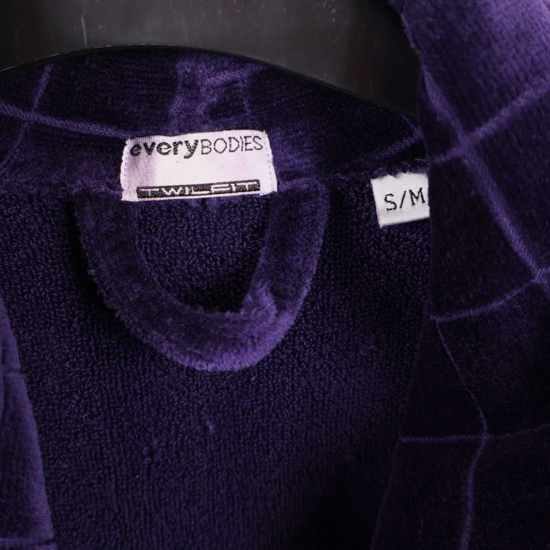 Närbild av etikett med everyBODIES och storlek S/M