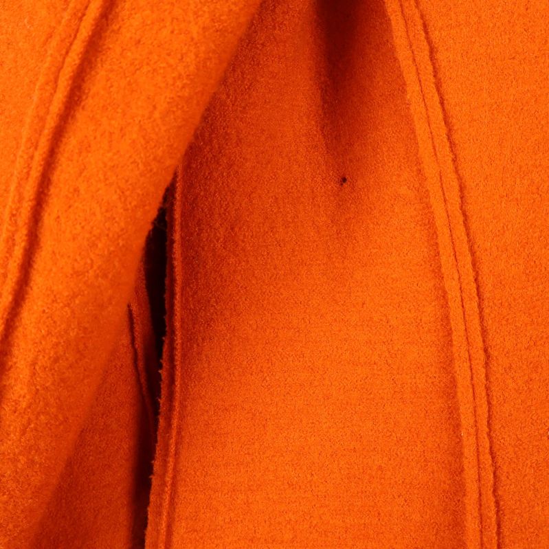 Närbild av orange tyg och sömmar på kappan