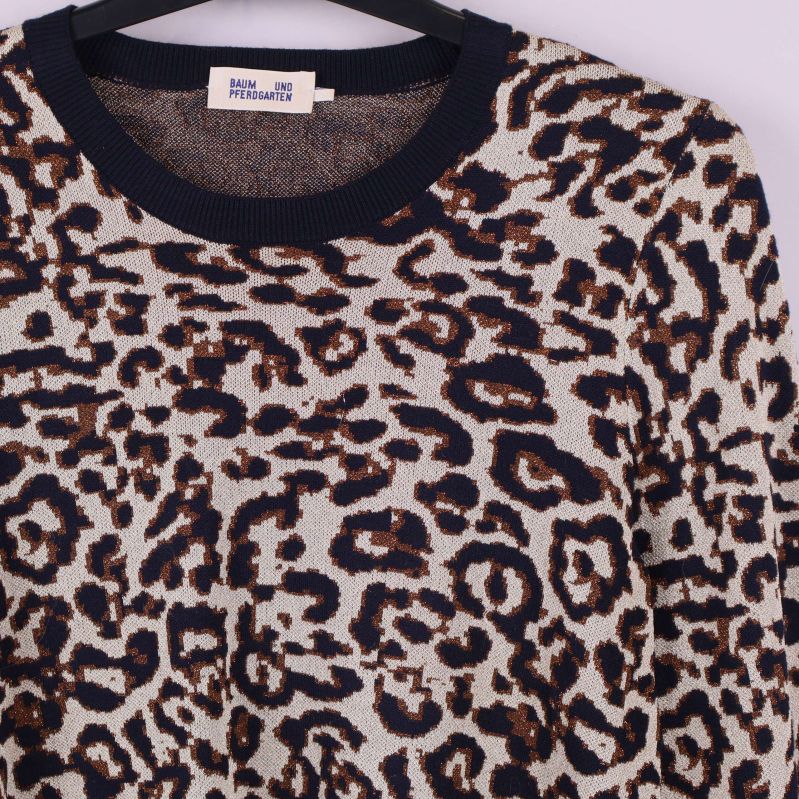 Närbild på tröjans leopardmönster och halslinning