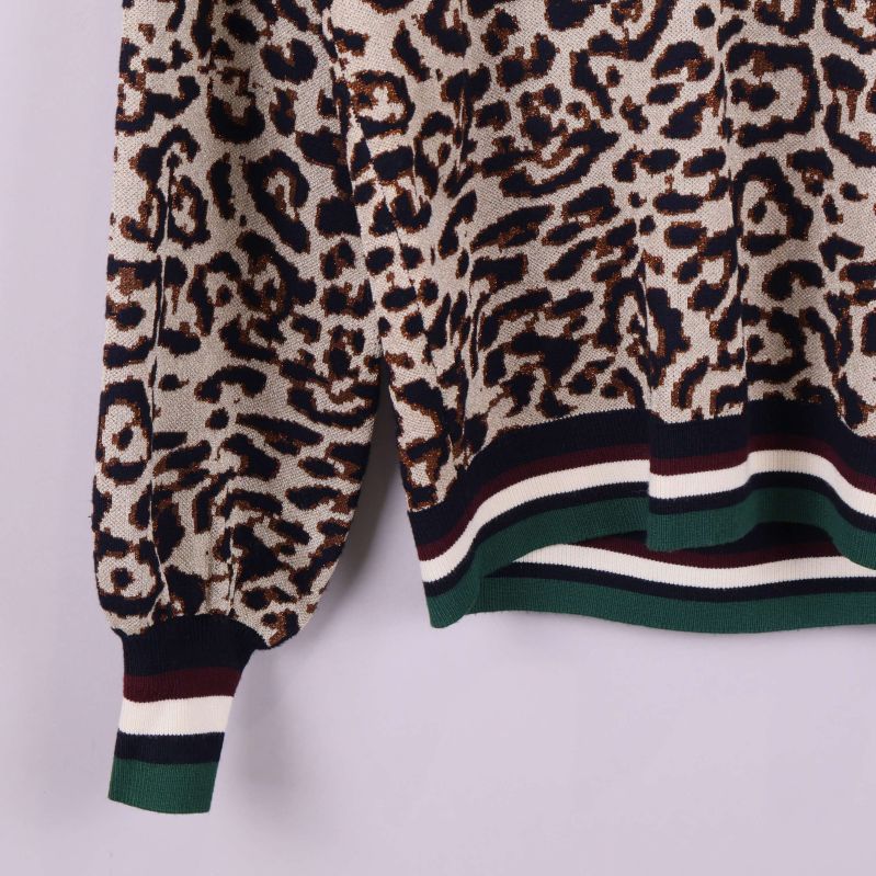 Närbild på tröjans nederkant och ärm med randiga muddar