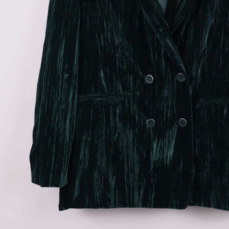 Nedre delen av mörkgrön sammetskavaj med fickor och knappar
