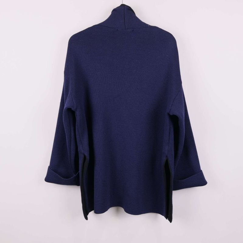 Baksida av samma mörkblå stickade tröja med uppvikta ärmar