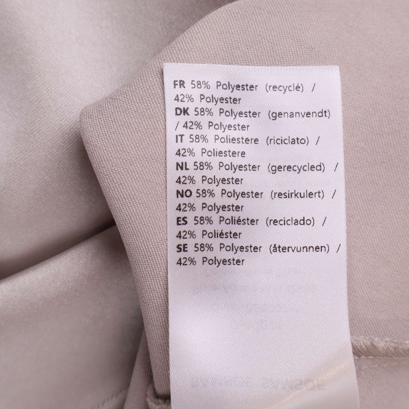 Materialetikett som visar polyesterblandning i kjolen