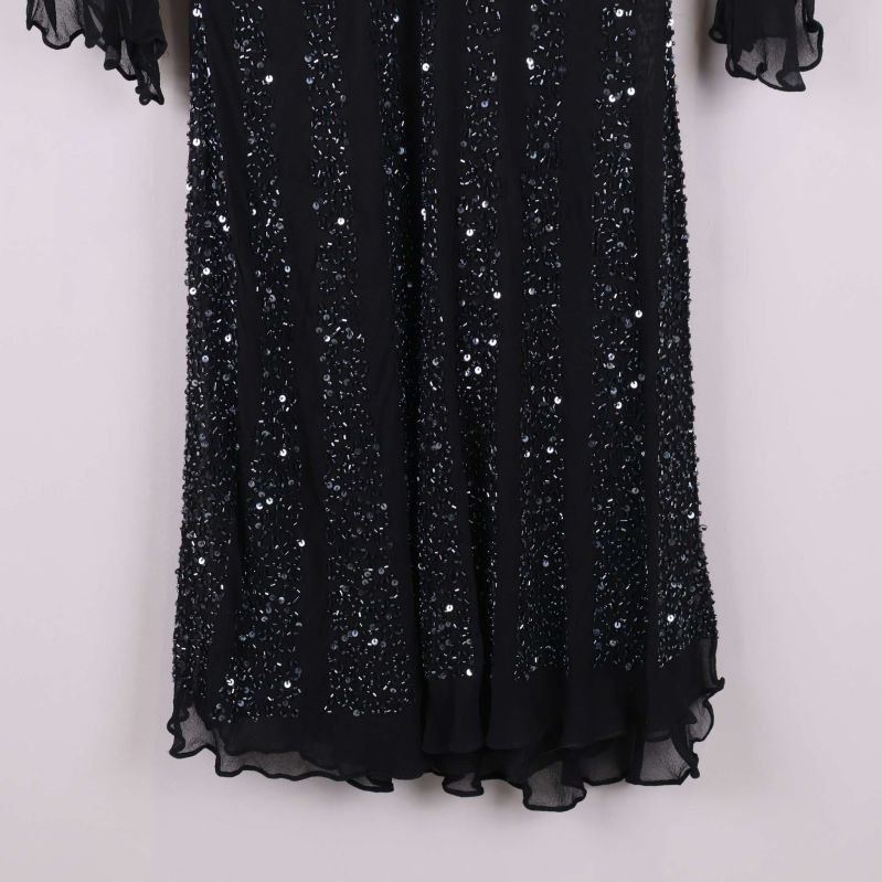 Närbild på klänningens nederdel med glittrande paljetter