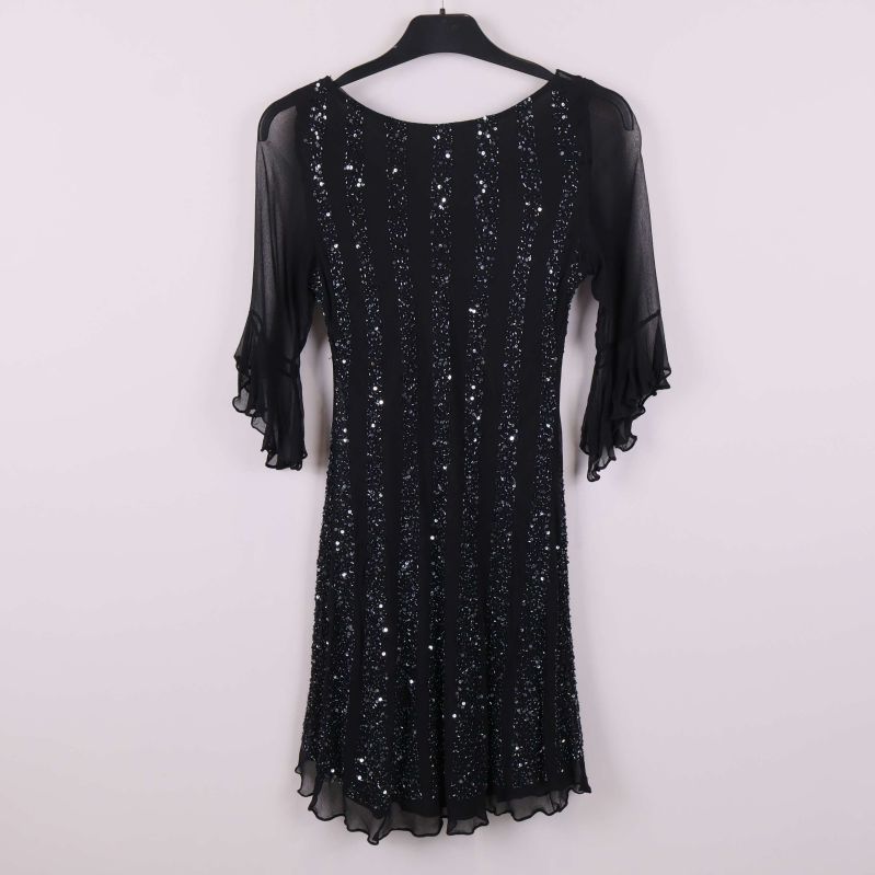 Baksida av svart klänning med paljetter och volangärmar