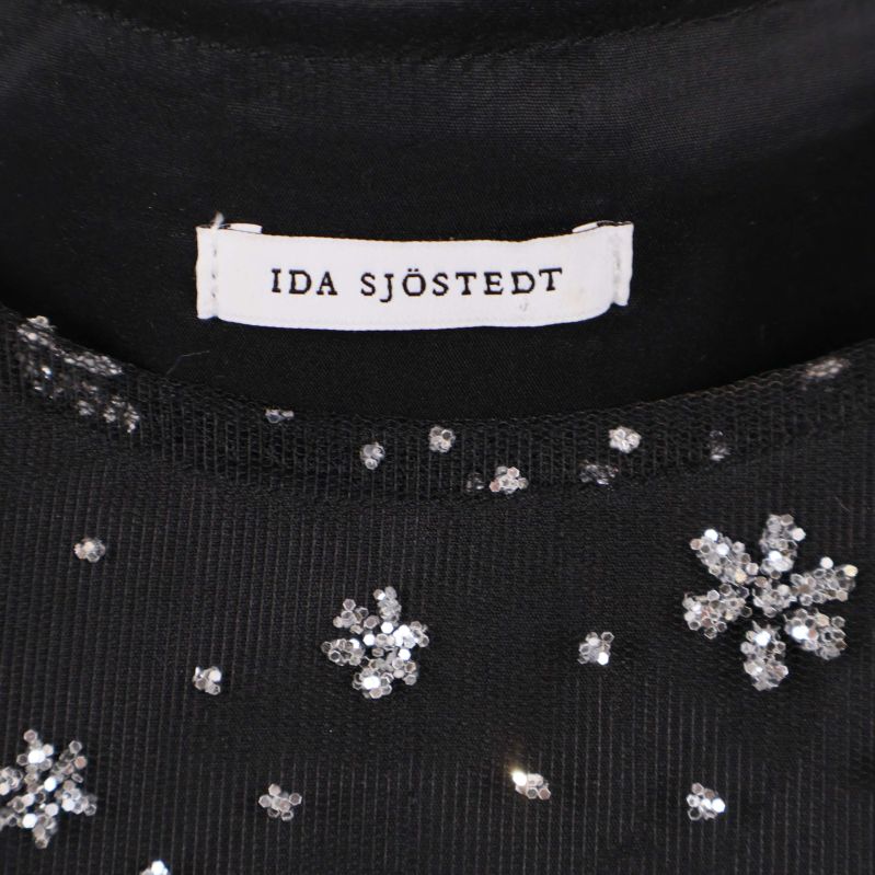 Närbild på Ida Sjöstedt etiketten i svart topp