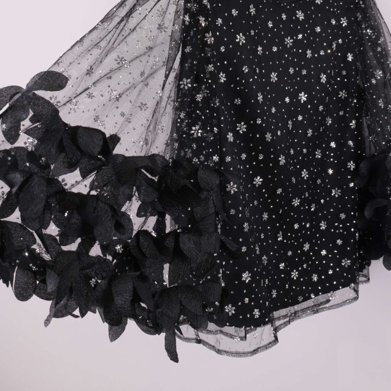 Närbild på utsvängd ärm med paljetter och bladdekor