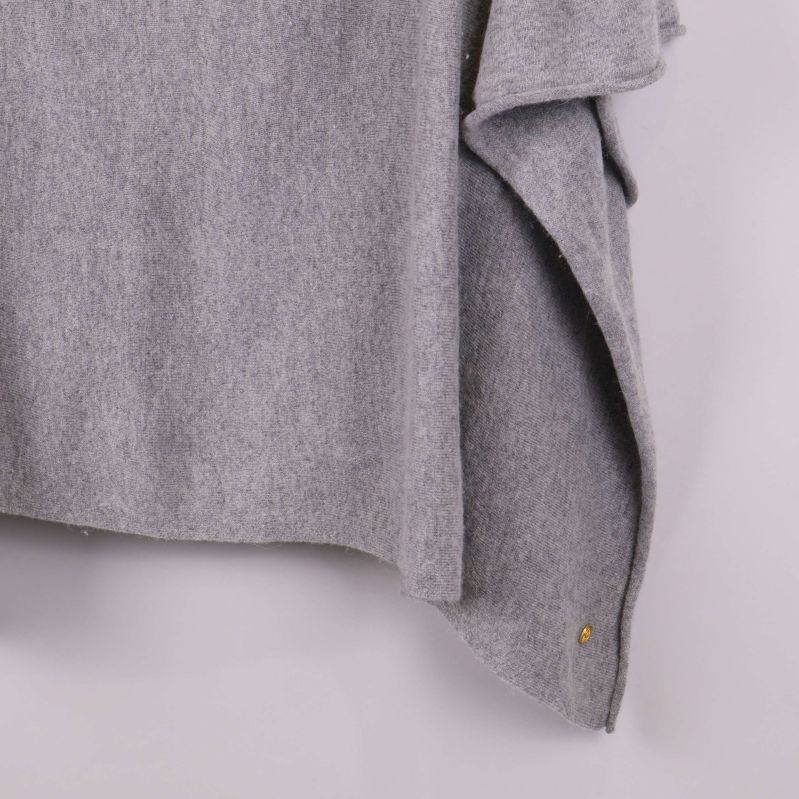 Detalj på ponchons nederkant och lösa tygflikar