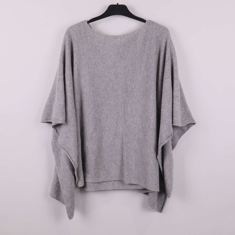 Ljusgrå poncho sedd bakifrån på galge