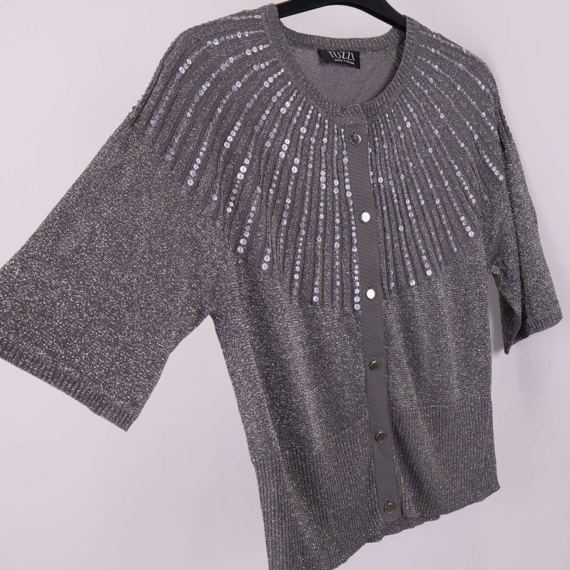 Snett perspektiv av kofta med paljettermönster och vida ärmar