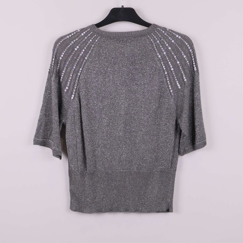 Baksida av grå kofta med paljetter i strålande mönster