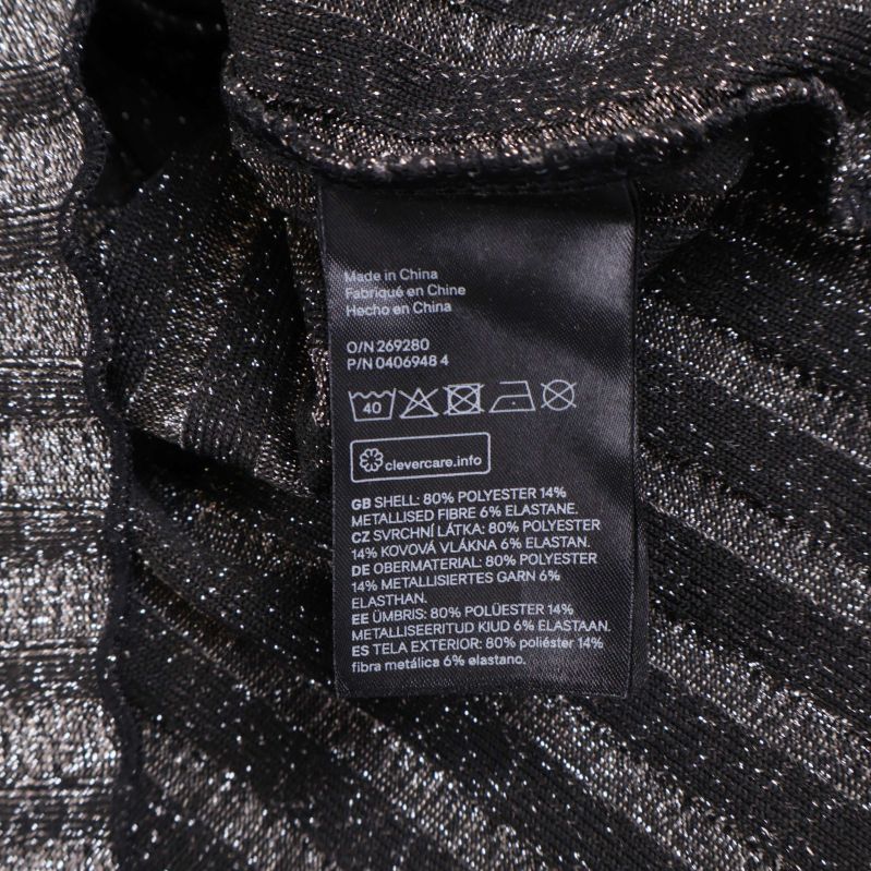 Material- och tvättrådsetikett på stickad klänning, svart och silver