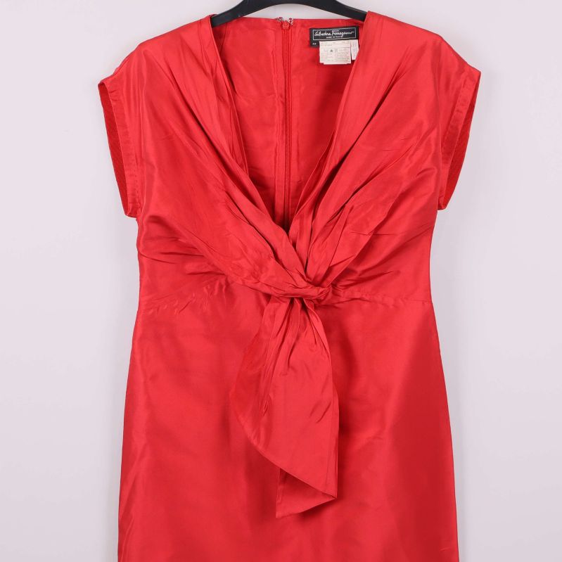 Närbild på röd klänning med veck och knyt framtill