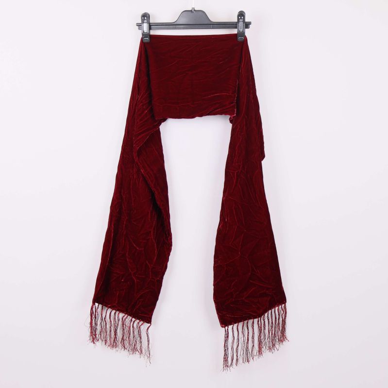 Vinröd halsduk med fransar hängande på galge