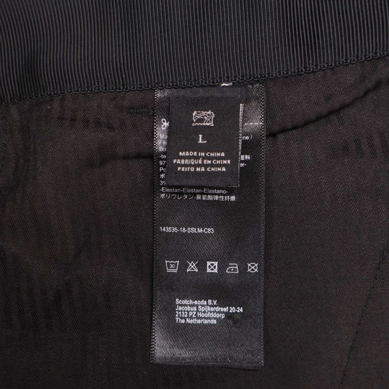 Svart etikett med storlek L i byxans insida