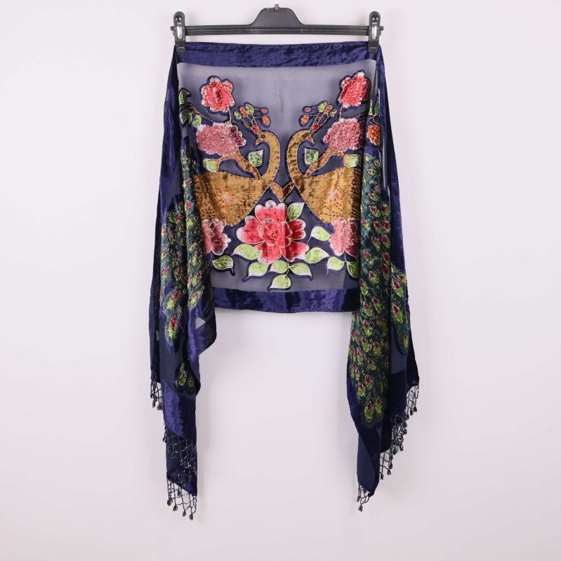 Sjal med påfågel- och blommotiv upphängd på galge