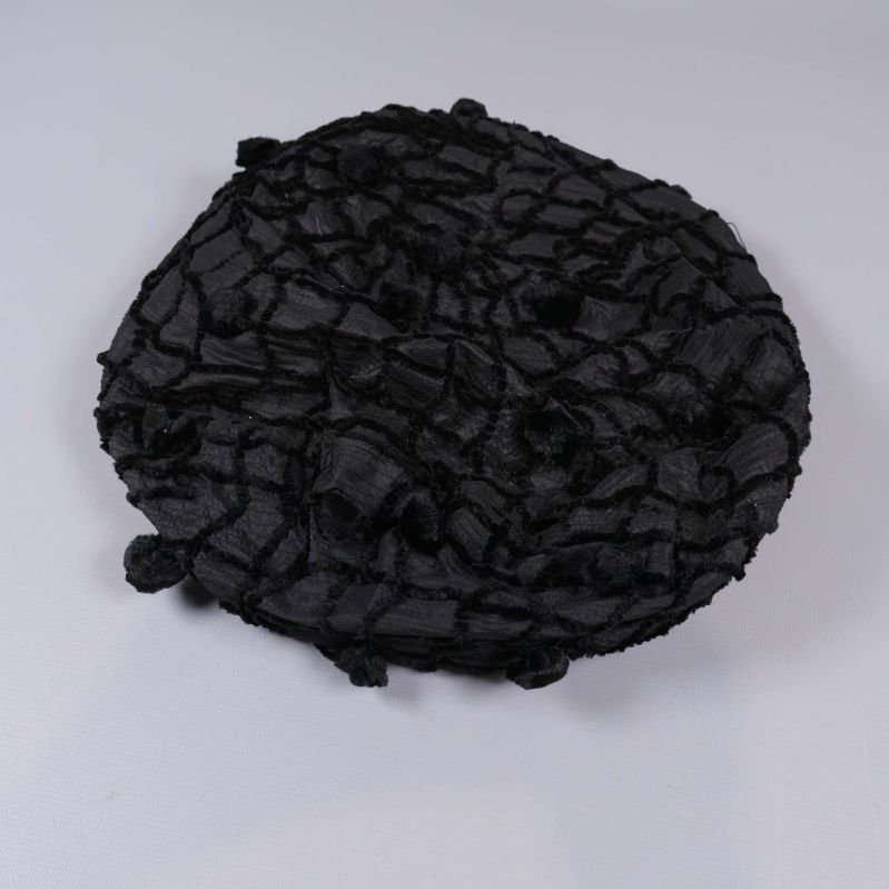 Platt vy av svart basker med struktur 