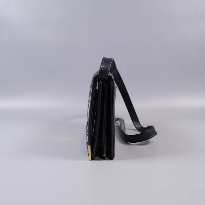 Väskans smala sida och lång axelrem i blått