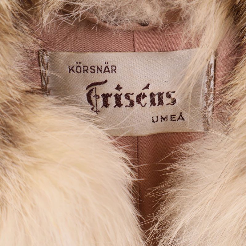 Närbild på etikett från Friséns Umeå i pälskappan