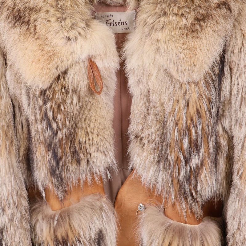 Närbild läderdetaljer och knäppning på pälskappa