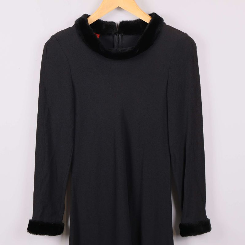 Övre del av svart klänning med fuskpäls på krage och ärmslut