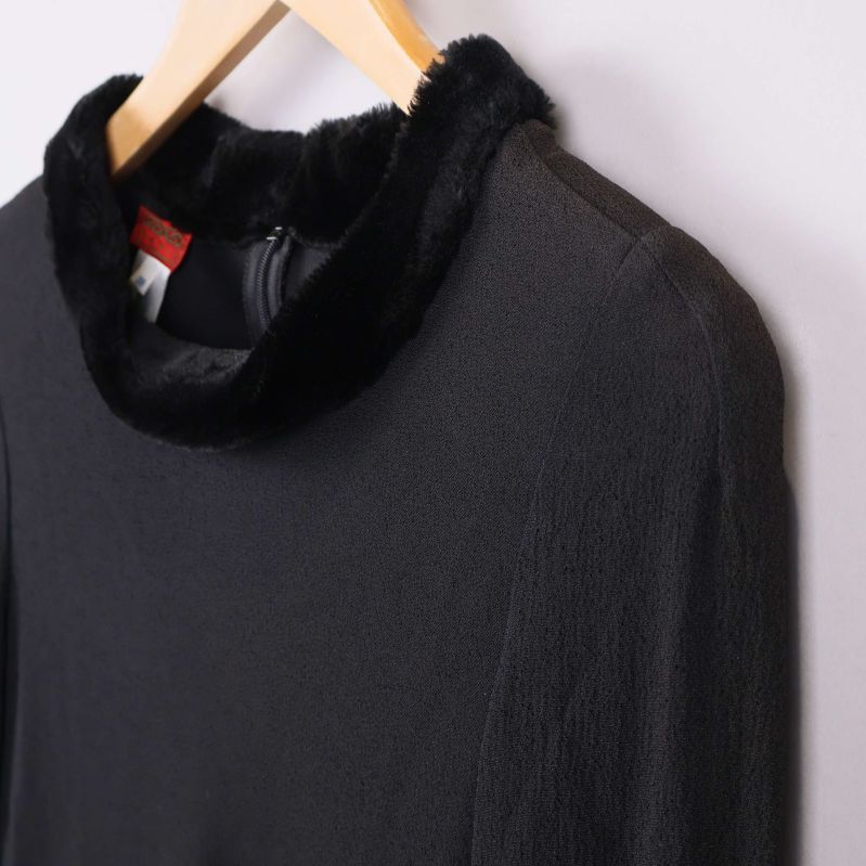 Närbild på krage med fuskpäls på svart tyg