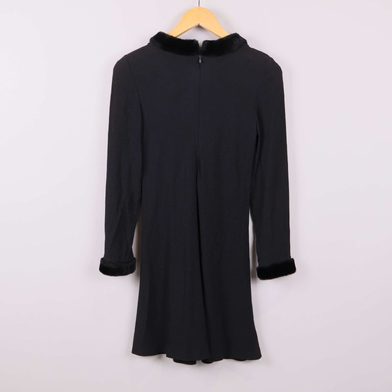 Baksida av svart klänning med dragkedja och fuskpäls