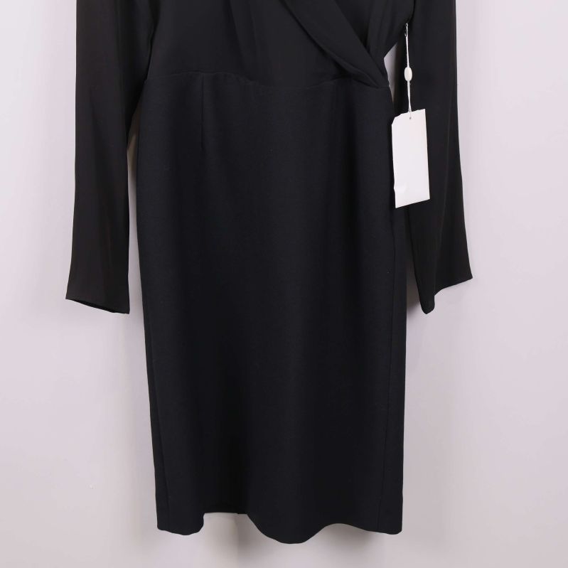 Närbild på nederdelen av svart långärmad omlottklänning