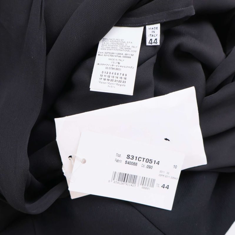 Två etiketter med modellnummer och storlek på svart klänning