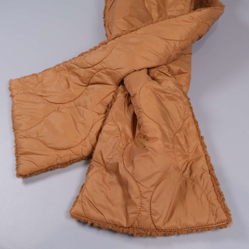 Närbild på korslagd quiltad halsduk i beige