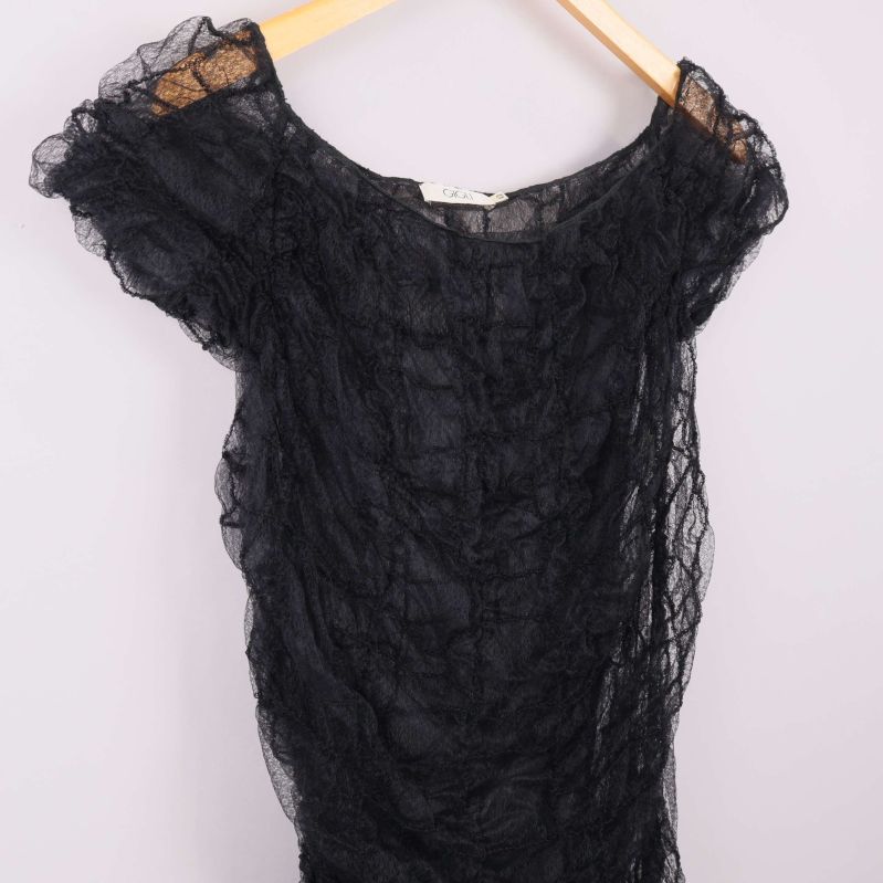 Närbild upptill på svart draperad klänning