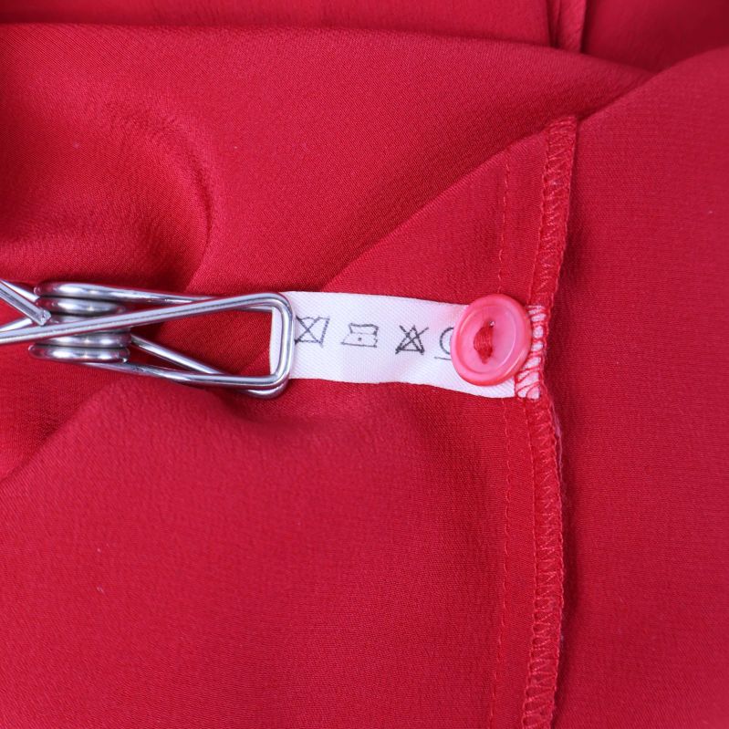 Tvättsymboler och sömdetaljer på blusens insida