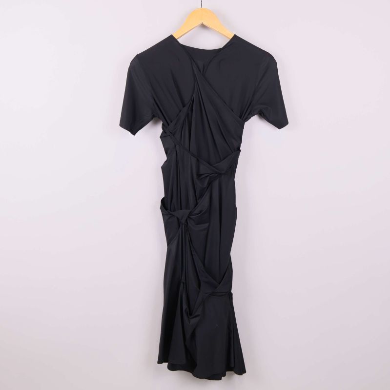 Baksida av svart draperad klänning 