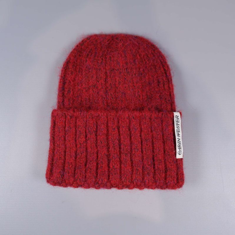 Röd ribbstickad mössa mot ljus bakgrund