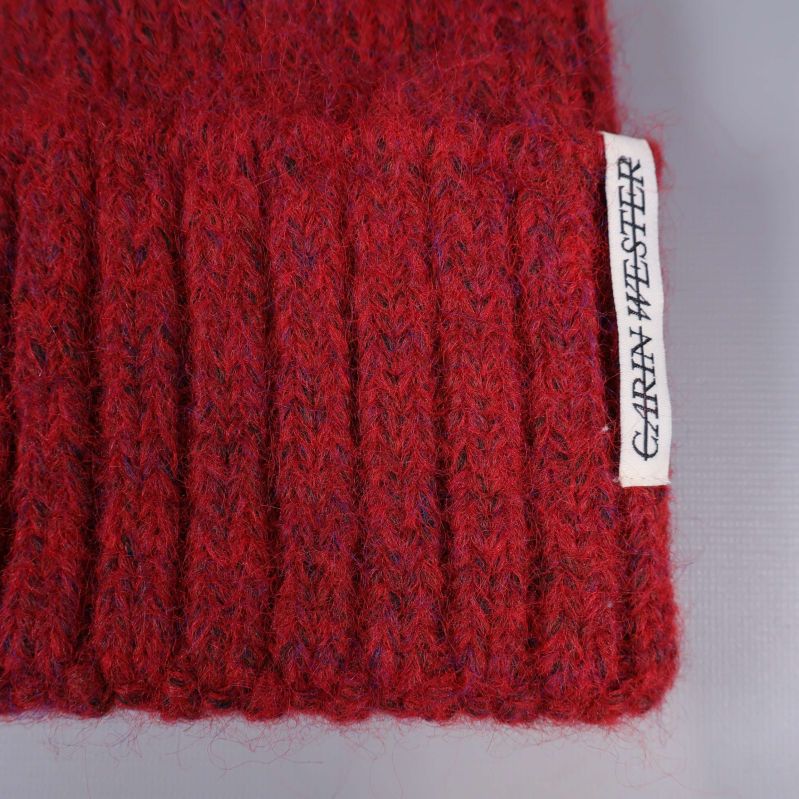 Närbild på röd mössa med Garry Wester etikett