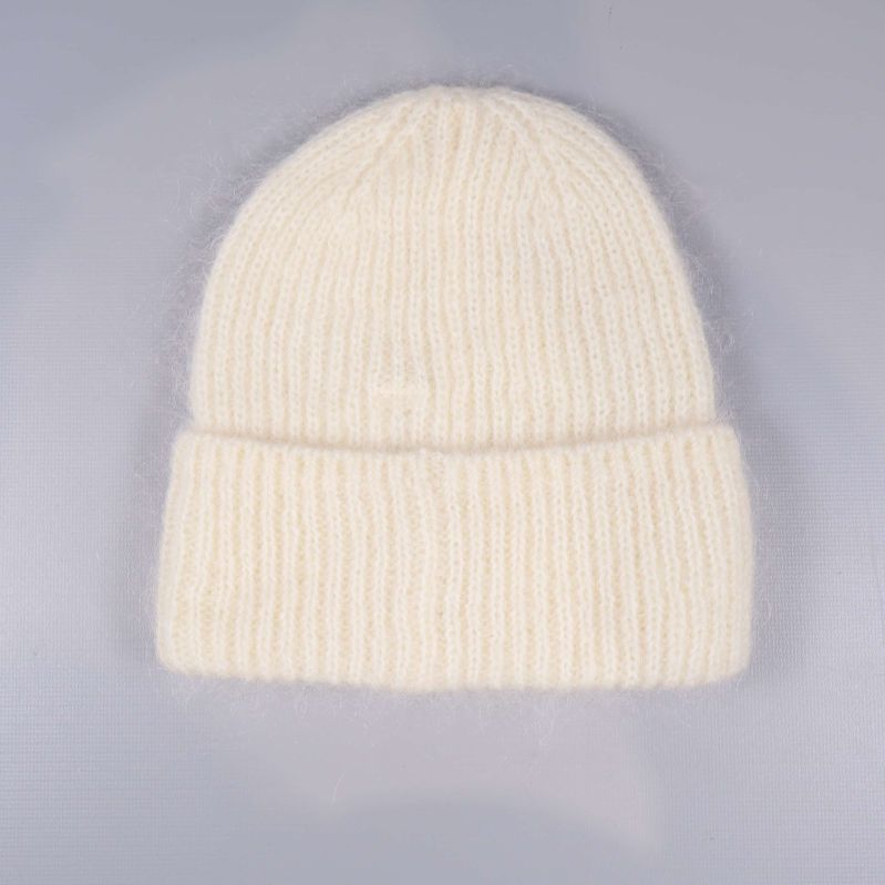 Baksidan av vit stickad mössa liggande på bord