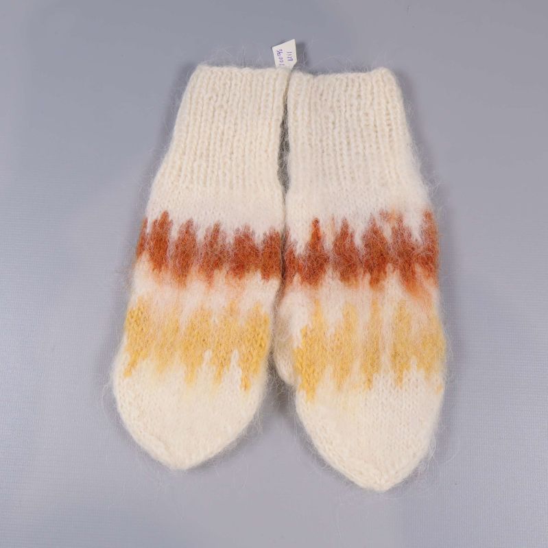 Stickade vantar med symmetriskt mönster i varma färger