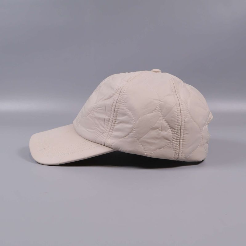 Beige keps i vänster sidovy med quiltade detaljer