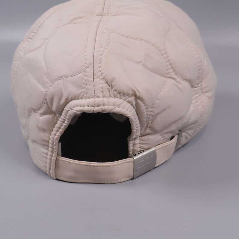 Baksida av beige keps med justerbar rem och spänne