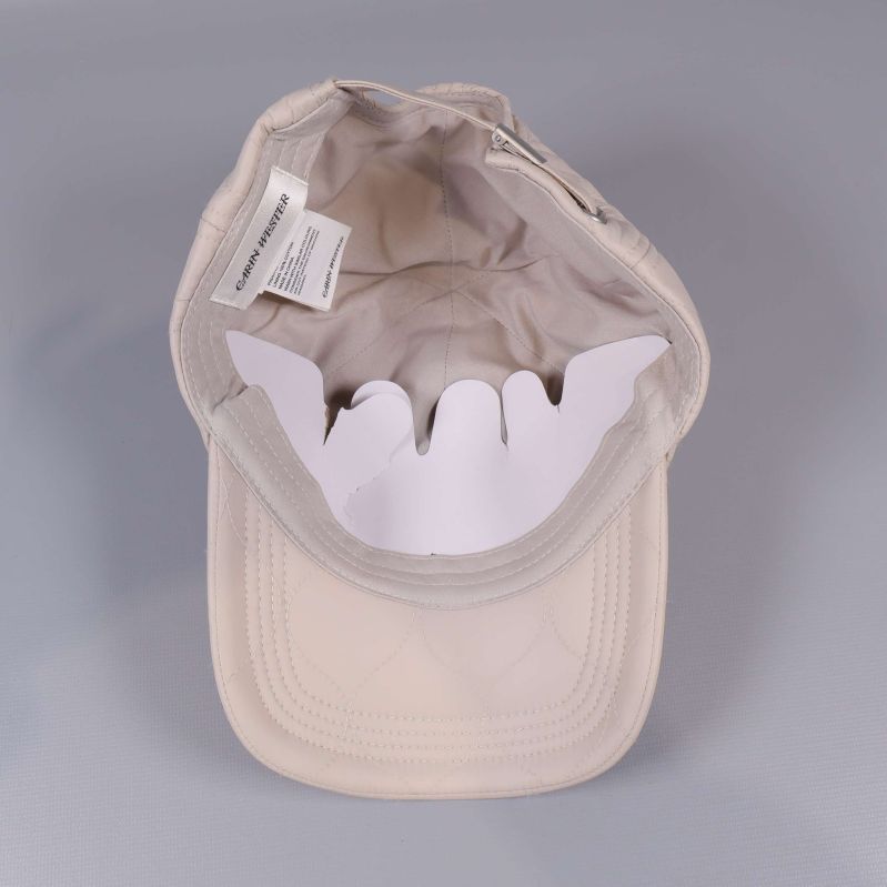 Invändigt av beige keps med etiketter synliga