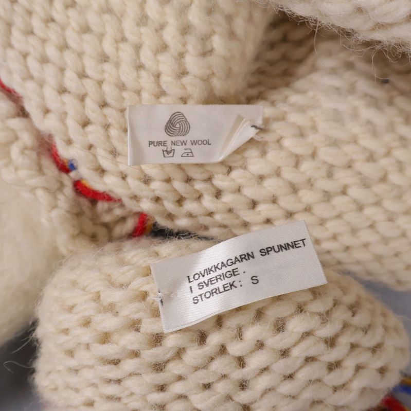 Etiketter med information om ull och storlek S på mössa och vantar