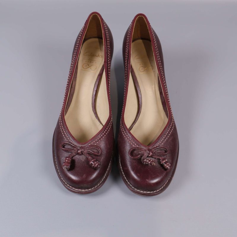 Pumps framifrån med dekorativa rosetter