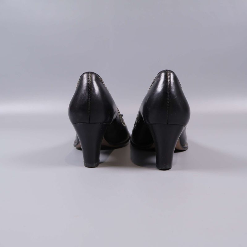 Baksida av svarta pumps med klackar mot kameran