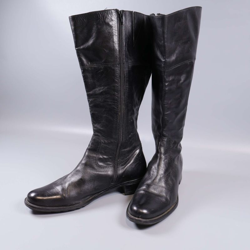 Höga svarta stövlar snett framifrån med synlig dragkedja