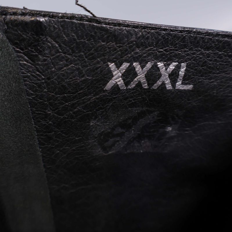 Närbild av stövel med texten XXXL inuti