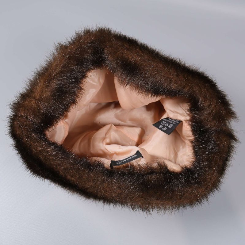 Insidan av mössa med beige foder och etiketter