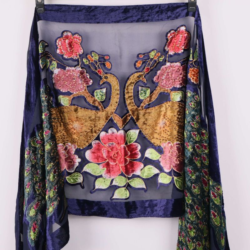 Närbild av broderat påfågel- och blommönster på sjal