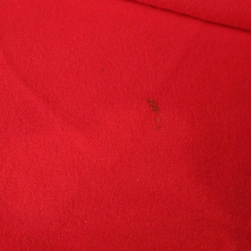 Närbild på röd halsduk med liten fläck