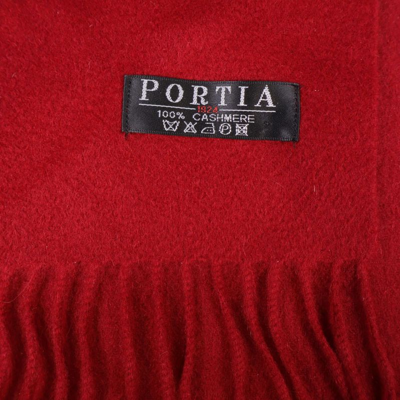 Svart PORTIA-etikett med text 100% CASHMERE på röd halsduk