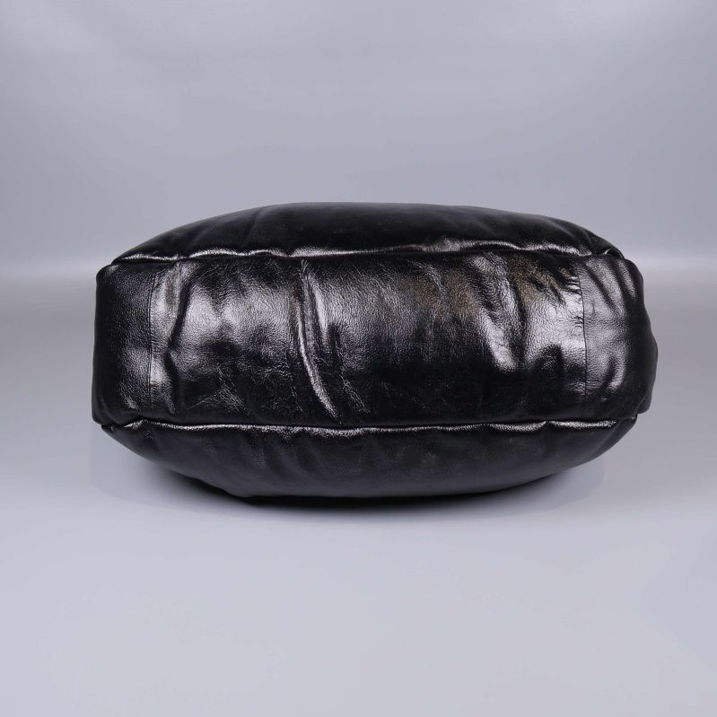 Underkant på svart väska i glansigt material